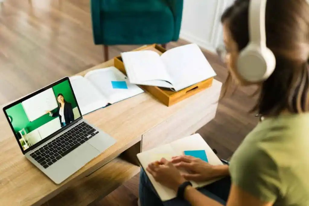 view of a young college student paying attention and listening to her online teacher