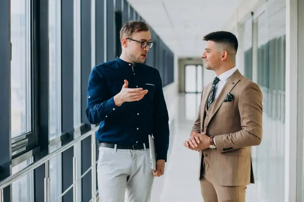 men stand in a hallway, engaged in conversation