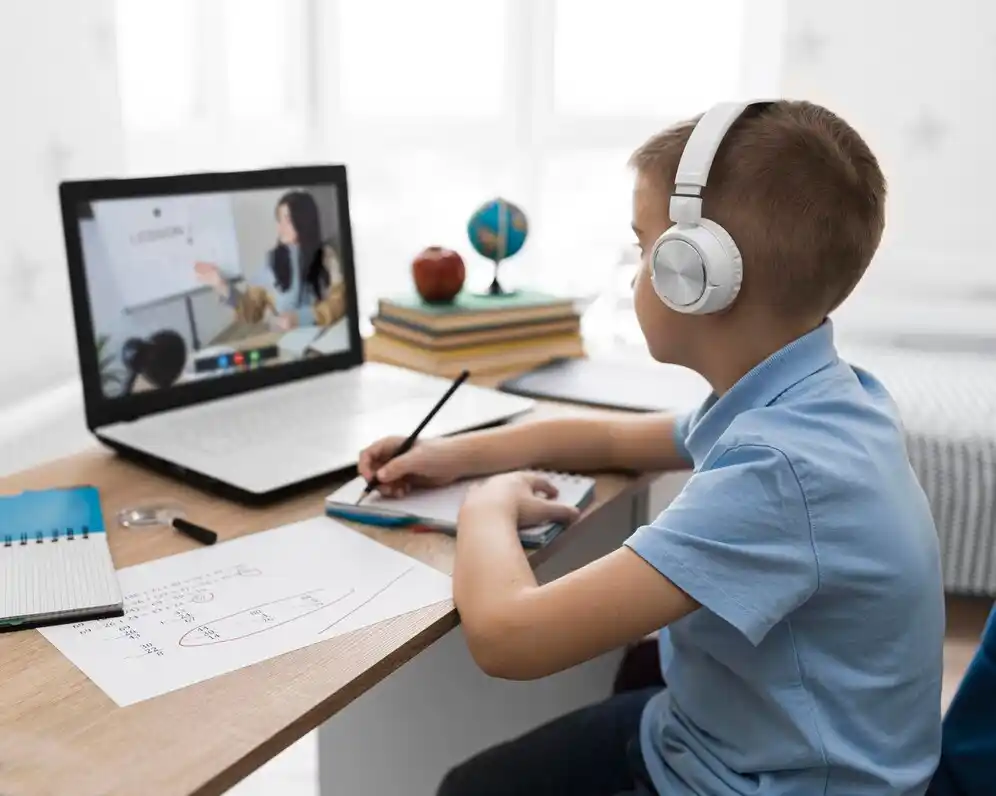 boy wearing headphones is engaged in online learning