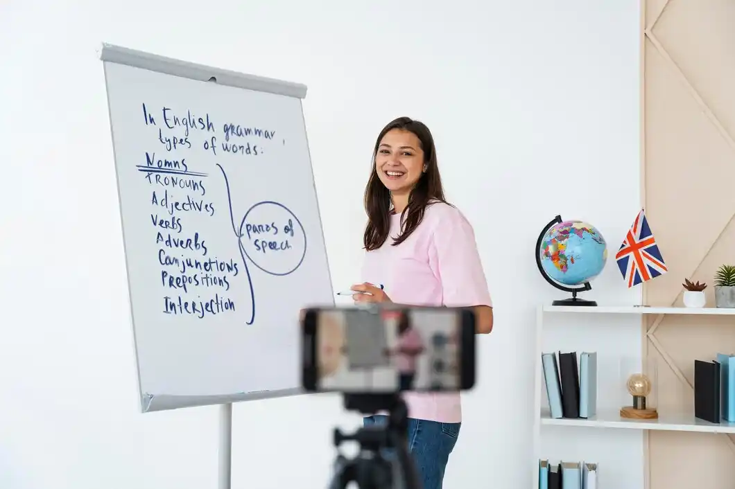 A woman in a pink shirt teaches English grammar, highlighting types of words.