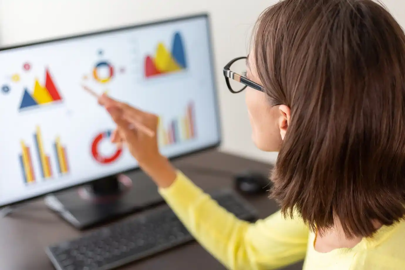 woman analyzes colorful graphs and charts on a compute