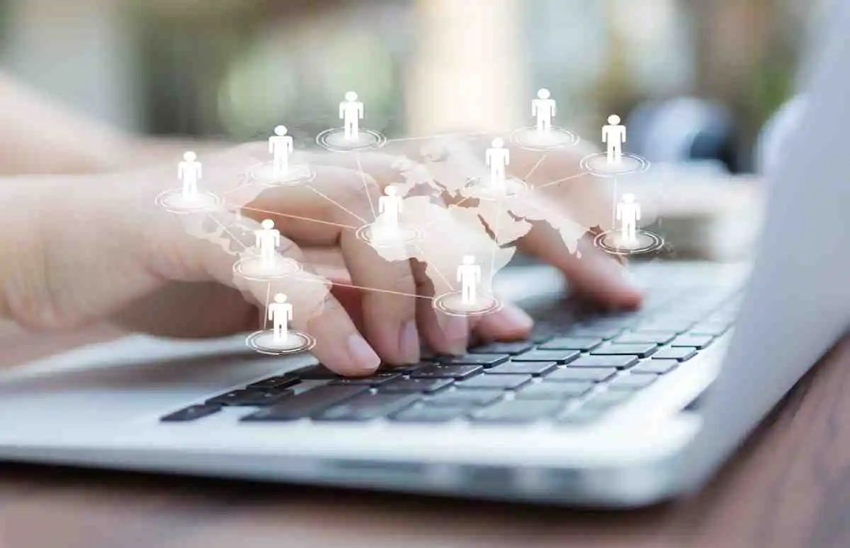 person types on a laptop with a graphic overlay of interconnected figures around