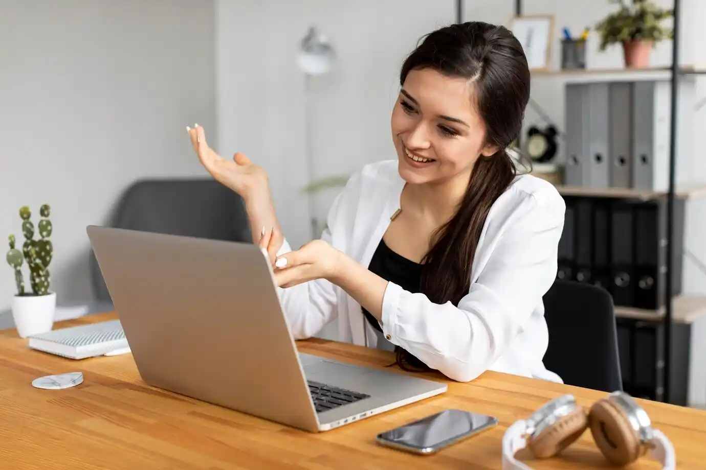 woman gestures while discussing in front of a laptop