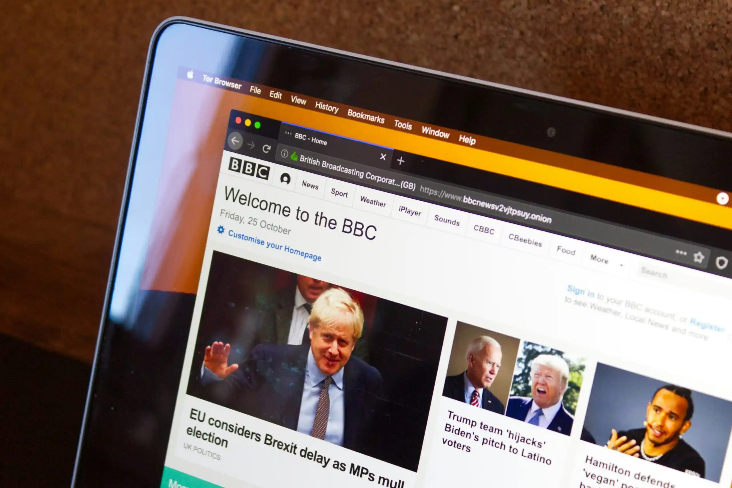 A laptop screen displaying the BBC website, featuring news headlines about Brexit and US politics.