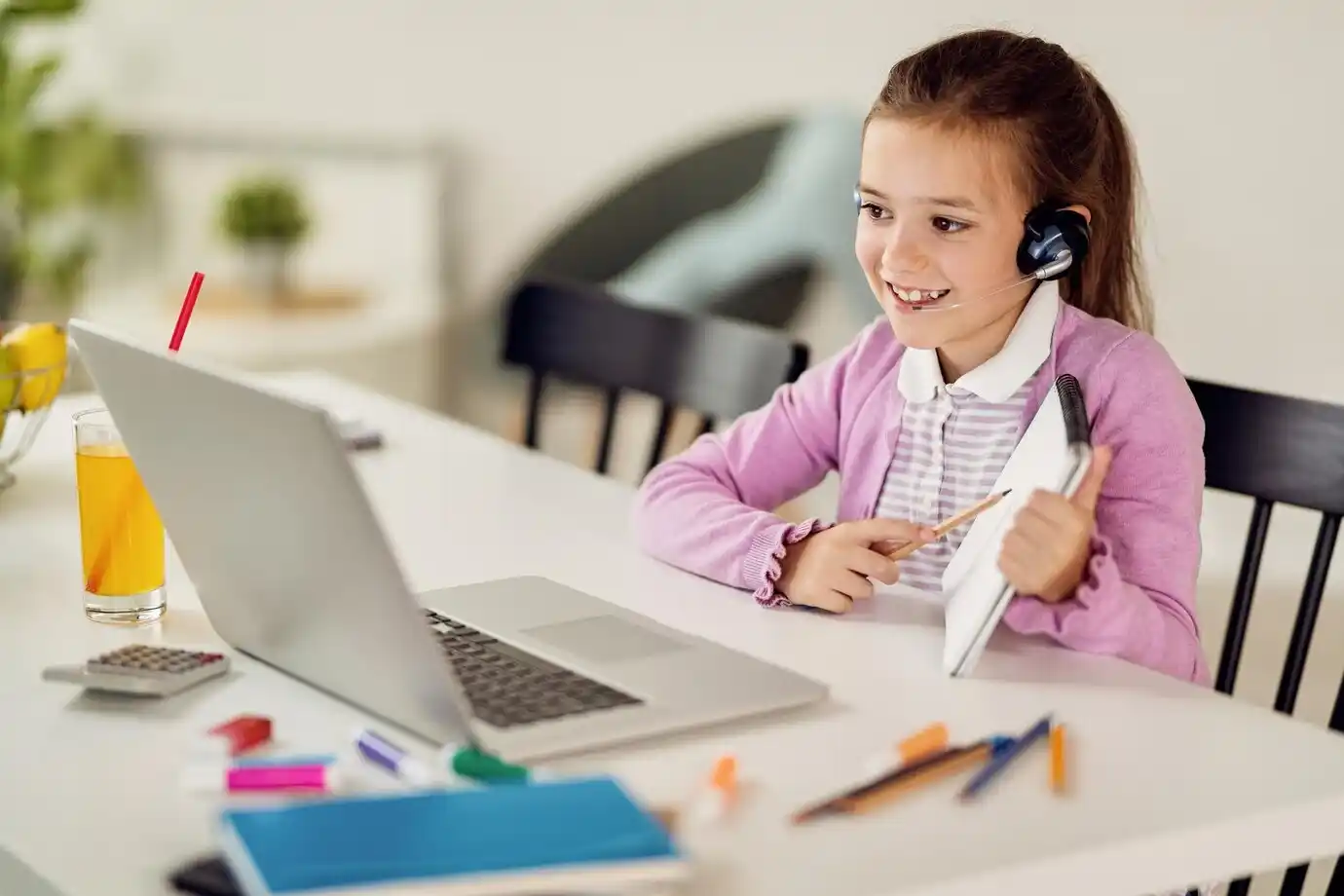little girl having online class with a teacher over laptop