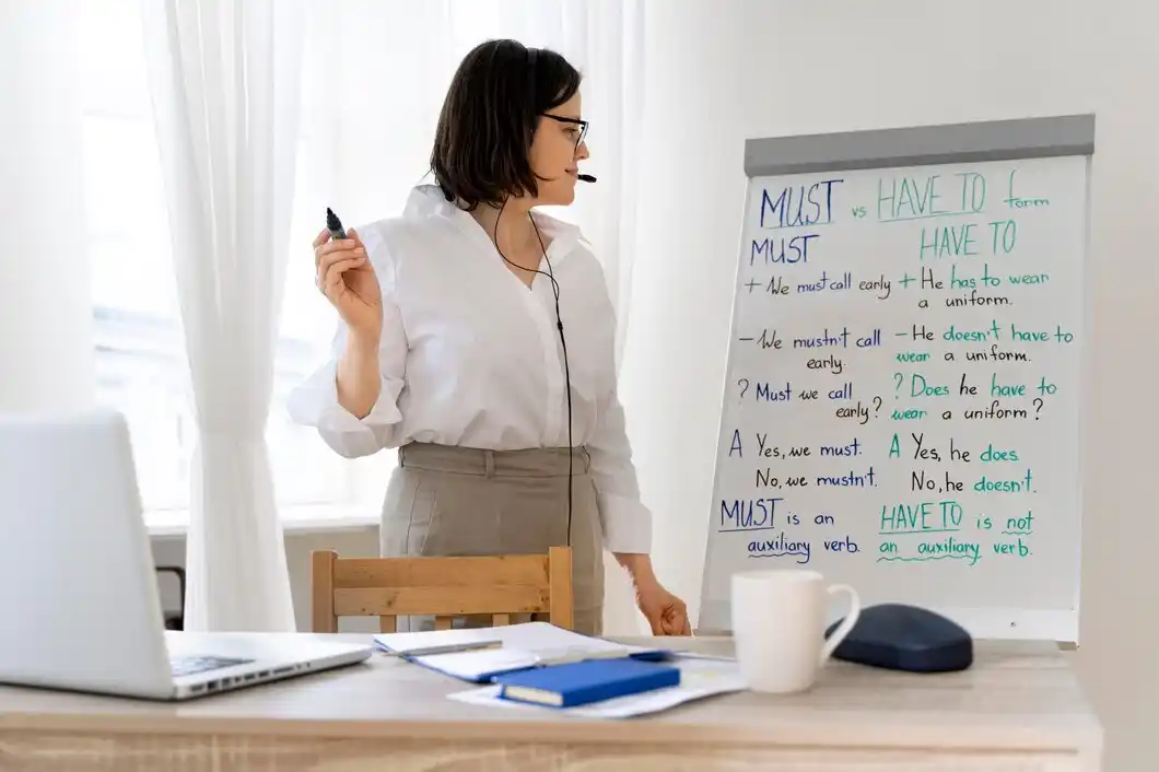 A woman in a white shirt stands next to a whiteboard explaining the differences.