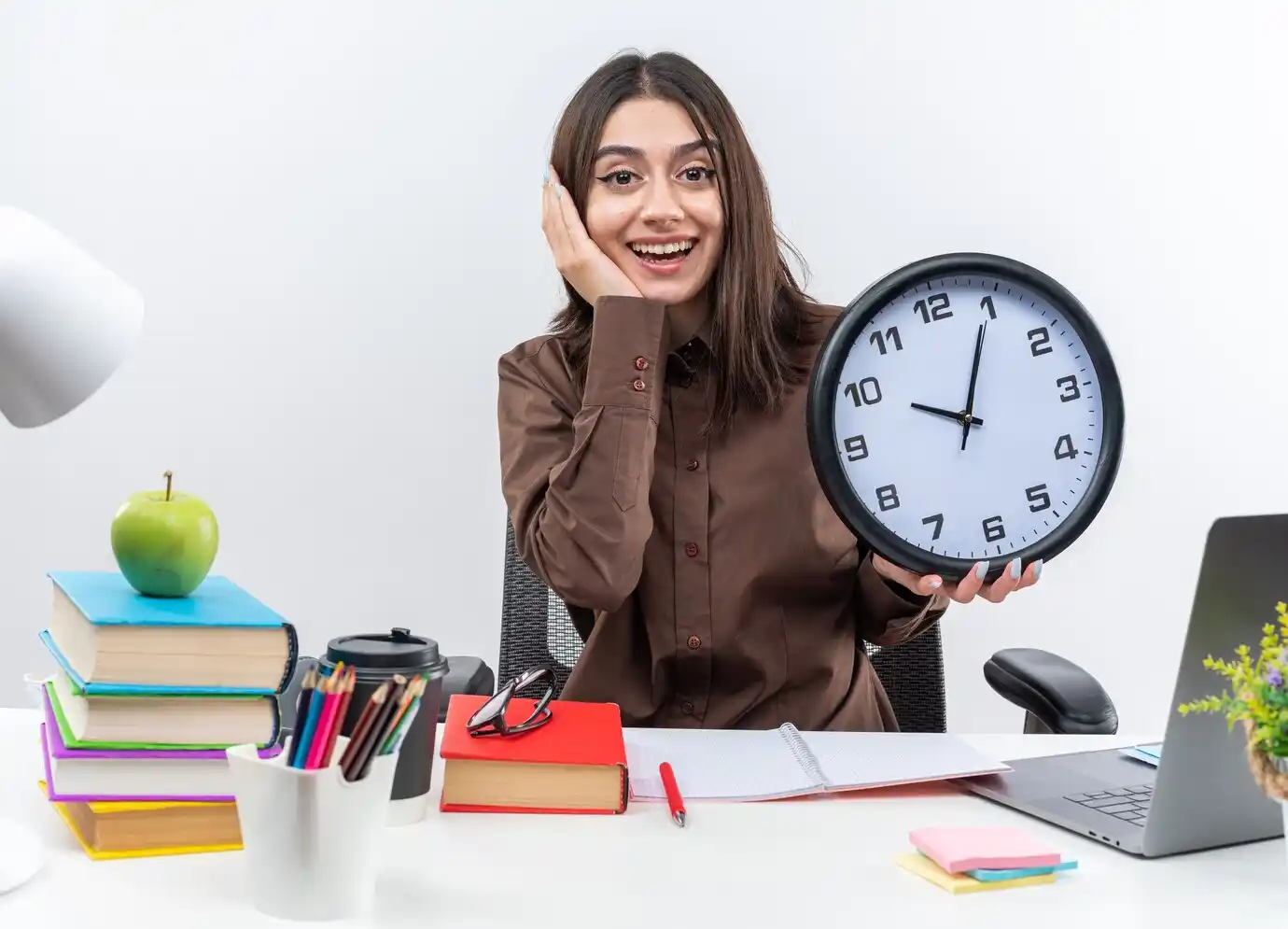 woman sits holding wall clock putting hand on cheek