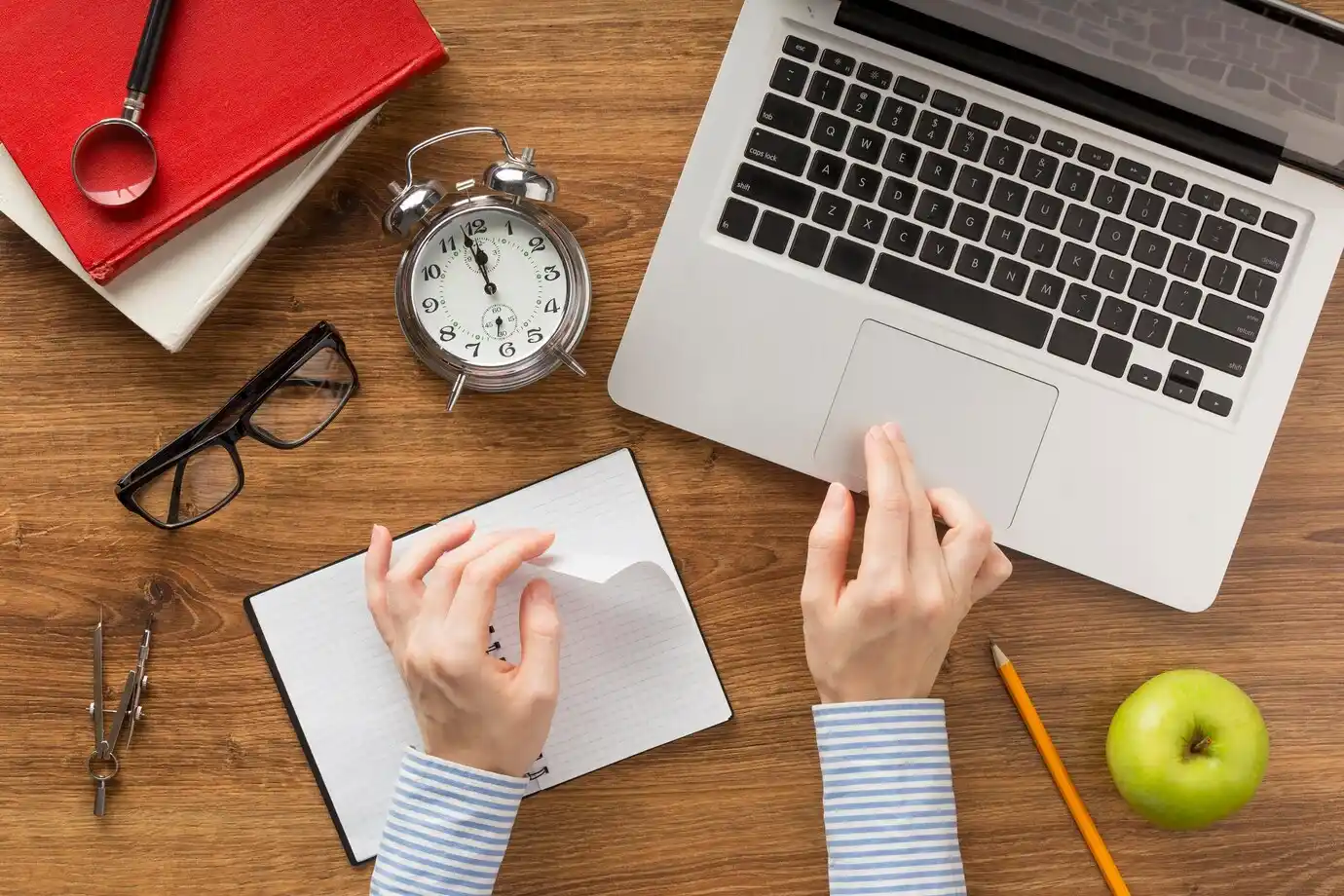 view of a table with a laptop, alarm clock
