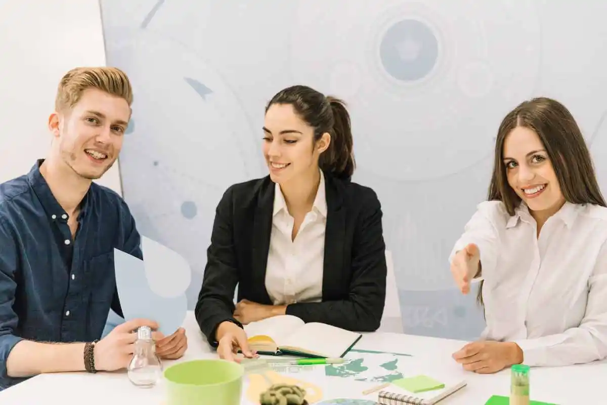 modern office setting, three individuals discuss ideas