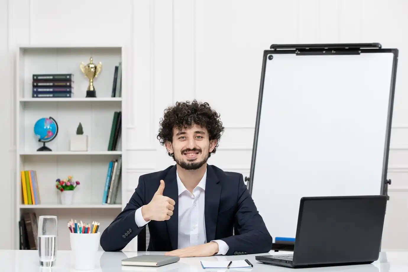 professional in a suit gives a thumbs-up while seated at an office
