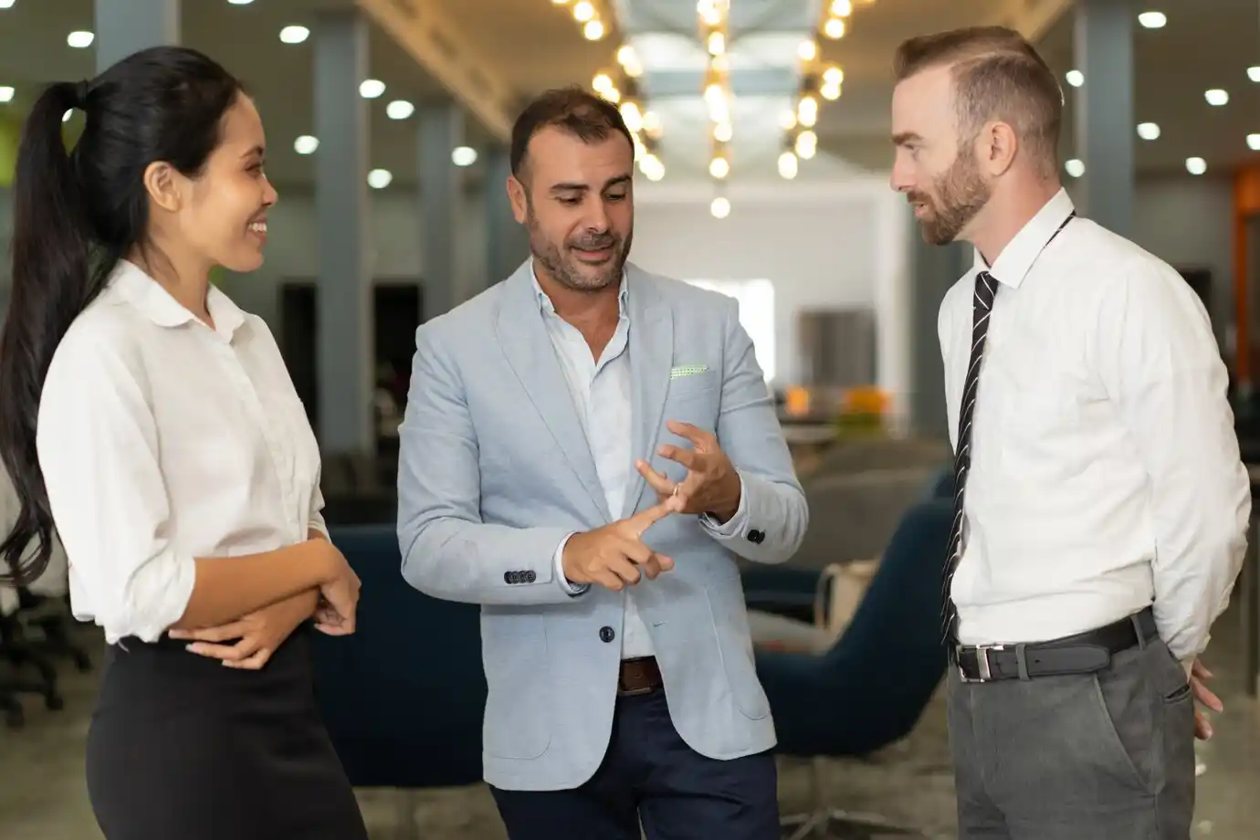 people in business attire are having a conversation in an office